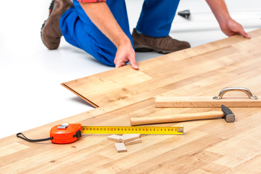 carpenter worker installing laminate flooring in the room