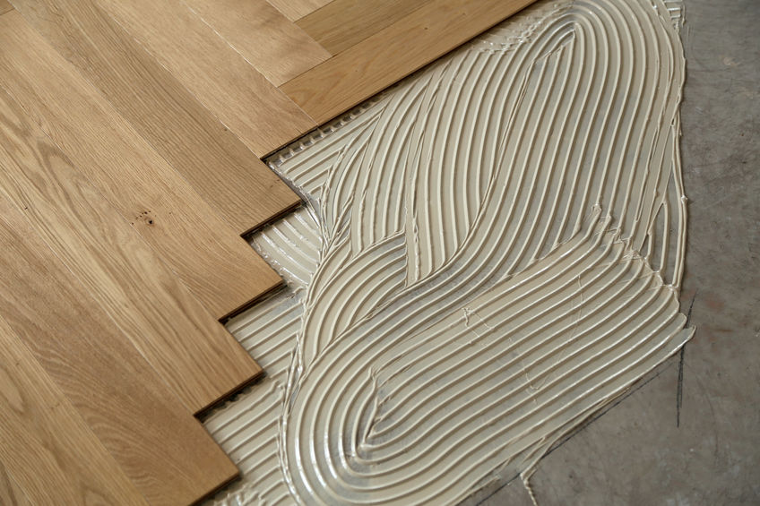 Construction in a renovated room installation of parquet. Pad applied with glue for parquet